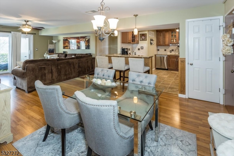 In town living at its best! So close to all the action in Morristown center yet set back on a hill that backs to state parkland for privacy & peace. Beautifully renovated in 2015, this 2 bed 2 bath 1 floor unit faces southeast so you can enjoy a bright sunny exposure  Attention to detail throughout! The Kitchen was redone in 2015 with granite countertops, wood cabinets, tile flooring & stainless steel appliances  Both baths redone in 2015 with tile flooring and quartz countertops.  Primary suite has 2 closets and a full bath with an amazing walk in shower and new glass doors installed in 2024. Newer laminate flooring throughout makes for easy cleanup.  The deck is protected on all sides with a ceiling so you can enjoy the newer tiled flooring and privacy screened railing.  All the windows and sliding glass doors replaced in 2015. The front of the building has new paver gardens to be landscaped in 2025. There is a gym for residents to use at no extra cost. Parking is rare & often an extra charge in many of the Morristown complexes.  Parking is free here with a  2 car maximum per unit;  one parking space assigned and one is first come first served. Lobby is secure and can only be entered if buzzed in from resident or with a key. The building has an elevator and additional storage for each unit is on the lobby level. Close to Rte 287, 202 and 10. Come enjoy the town's dining, theater & mid town train direct to NYC.. Then enjoy quiet living so close to town.