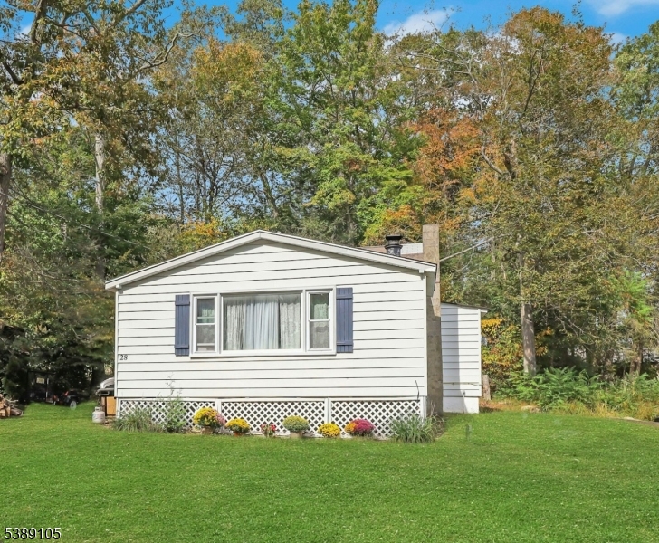 Cozy 2 BR ranch with Upper Greenwood Lake Property Assoc. lake rights (private beach, lifeguards, clubhouse, fishing, motor boats, water/jet skiing) located on an oversized .297 acre lot. Perfect starter home or second home for those seeking a quieter lifestyle. Large living room with sunny picture window and a wood burning stove. Loads of potential to expand utilizing the unfinished second floor. Knotty pine interior for a rustic, cabin-like feel. Enjoy Summers at the lake, and Autumn in nearby Warwick, NY.  New well pump and holding tank (2024), New water softening system (2023), new water heater May 2026. Don't miss this one!!!