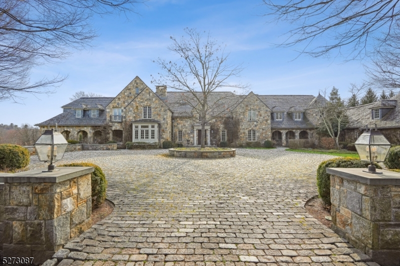 Spectacular Granite Stone Estate w/ Vermont slate roof & copper leader & gutters, designed by noted architect Hiland Turner & custom built for owner in 2001, on over 8.5 acres of stunning, totally level property, adjacent to 30 Acres of conservation property, owned by Harding Land Trust, ideally located in the heart of Harding Township. The 16,042 sq ft manor house includes incredibly high ceilings, 9 fireplaces, bluestone terraces, open porches, a stunning saltwater gunite pool, gazebo, built-in BBQ, tennis court, attached & detached garages w/ future apartment & breathtaking views of the property. This grand home offers unparalleled lux living, exquisite architectural details & high end finishes throughout. There are 7 garage bays, perfect for the car collector. The Gourmet eat-in Christopher Peacock Kitchen is a chef's paradise, & opens to Family Room, w/custom paneling & gas FP. The Living Room, w/coffered ceiling, perfect for entertaining & has dual fireplaces. The Library has floor to ceiling custom mahogany paneling, fine custom cabinetry w/gas FP & loft. The Formal Dining Room w/gas FP will impress. Billiards Room w/ FP, an ensuite bedroom, office, den w/custom built-ins, mudroom & 2 powder rooms. The lux Primary Suite w/ massive dressing rm & spa-like bath w/heated floors, soaking tub & Shower. 5 bedrooms, exercise room, sitting room/loft, & laundry room complete the 2nd flr. Lower level is beautifull w/Rec Room w/wet bar, golf simulator room & Train Rm. Low Taxes!