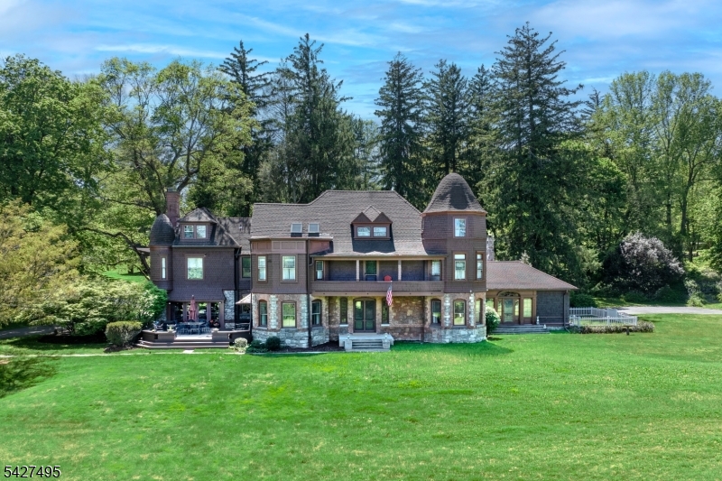 One of the original Bernardsville Mountain Colony's treasured properties has become available on 8.1 acres on a roadway now home to so many prominent new estates. Built by George I. Seney in 1881 for his son, the accomplished architectural firm of Lamb & Rich designed the high style shingle and stone home. The property was purchased in 1890 most notably by Charles Pfizer, owner and master of the Essex Fox Hounds and the chemical company that bares his name. He called it 'Yademos', or 'Someday' spelled backwards. Many of its original features have been preserved by subsequent owners including the wicker-work balustrade in the entry stair hall; the brilliantly tiled fireplace hearth in the Grand Ballroom; the broad balcony that stretches across the front of the home; elegant dining room; and beguiling turret rooms for card games and office space. 6 bedrooms are now supported by a 2025 8-bedroom septic and the house warmed by 8 zones of gas or oil heat and cooled by central air. The kitchen was designed by Canterbury and opens to a light-filled breakfast room with fireplace and attached greenhouse. The versatile 3rd floor contains a full apartment of rooms that include a kitchen, dining area, bedroom and office. A 25'x50' heated pool and a handsome newer barn occupy land once part of Pfizer's famous Japanese Garden uphill from the house. Featured in Vol.1 of Jack Turpin and W. Barry Thomson's 'New Jersey Country Houses/The Somerset Hills', this is a rare and unique treasure.