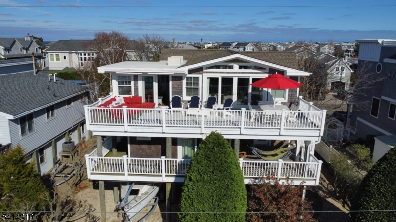 Welcome to this stunning 4-bedroom, 3.5-bath shore retreat located in the heart of Harvey Cedars in the highly sought-after Kinsey Cove neighborhood. Designed with effortless coastal living in mind, this beautifully maintained home has been thoughtfully updated with today's on-trend colors and finishes, creating a bright and inviting atmosphere perfect for relaxed shore living and entertaining alike. Multiple decks offer wonderful spaces to unwind while enjoying bay views and refreshing coastal breezes, whether you're starting the morning with coffee or gathering with friends after a perfect beach day. The home's comfortable layout was designed for memorable nights at the shore, offering generous living spaces and a seamless indoor-outdoor flow. Ideally located in the center of Harvey Cedars, you'll enjoy easy access to beautiful beaches, wonderful local restaurants, the local favorite - Neptune Market, charming shops, and all the small-town coastal charm this beloved LBI community offers. Spend the afternoon exploring the nearby historic Barnegat Lighthouse, biking along scenic streets, or enjoying sunsets along the bay. Additional highlights include a spacious two-car garage perfect for parking, storage, or extra recreation space, a paver driveway, convenient outdoor shower, and updated mechanicals providing comfort and peace of mind. Every detail has been thoughtfully considered in this exceptional home. You will love calling this Harvey Cedars gem your own.