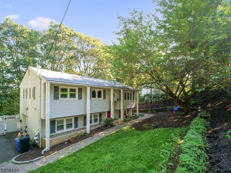 LAKE VIEWS, IN GROUND POOL, Enjoy peaceful views of Lake Hopatcong from the backyard of this spacious and inviting bi-level home, offering a wonderful blend of comfort, space, and outdoor living.This 3-bedroom, 1.5-bath residence features generously sized living and dining rooms, perfect for both everyday living and entertaining. The kitchen was updated previously and provides ample cabinetry and functionality. Hardwood flooring adds warmth and character throughout much of the home, and all bedrooms are well-proportioned.The ground level offers a large recreation room ideal for gatherings, movie nights, or casual relaxation, along with an additional flexible room that works beautifully as a home office, guest room, or hobby space. Step outside to a backyard designed for enjoyment, featuring a deck and an in-ground pool an ideal setting for summer entertaining.  Additional highlights include a 1-car garage, public water, and public sewer. The home has just been recently painted for a fresh look . Also, please note, the springtime photos of the deck was before it was painted ...it's now gray. A must see! Chimney is as is