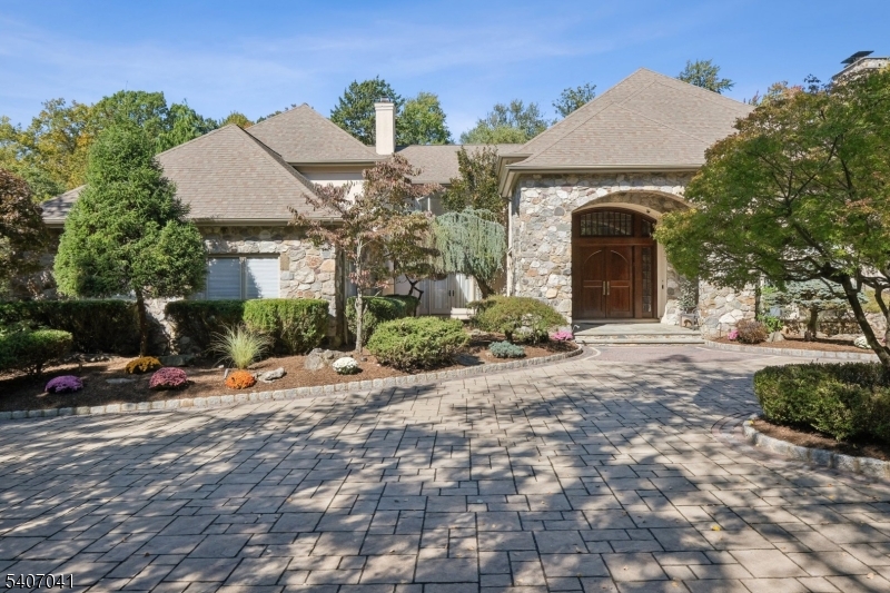 With an incomparable setting and total privacy front and back, this home presents an exceptional opportunity in Livingston's prestigious Bel Air neighborhood. This custom, Tuscan-inspired residence offers a rare blend of privacy, space, and resort-style living, built with unsurpassed craftsmanship including solid I-beam construction you can feel underfoot. Designed for both relaxation and entertaining, the property features a heated pool with spa, hot tub, fire pit, covered bluestone patio for dining and lounging, and a large, level lawn ideal for play, sports, or gatherings completely surrounded by a lush wooded perimeter. A circular drive leads to a dramatic arched entry and mahogany doors opening to a grand two-story foyer with limestone floors. Inside, the home is warm and inviting with rich wood floors, sun-filled rooms, a chef's kitchen open to gathering spaces, and a striking octagonal breakfast room with wood ceiling. The first floor includes a sunken living room with fireplace, formal dining room perfect for holidays, spacious family room, and a secluded office ideal for work-from-home. On the second floor, the primary suite features a balcony overlooking the backyard, two walk-in closets, and a spa-like bath plus three additional bedrooms, laundry room, and a cedar storage room. The walk-out lower level adds flexibility with a sun-filled gym, sauna, space for play, guests, or media, and incredible storage-- your own private retreat just 25 miles from NYC.