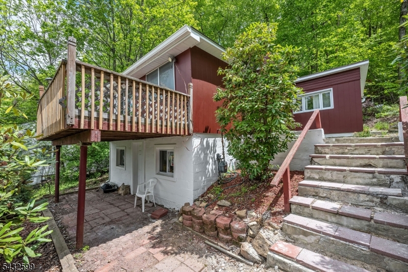 Panoramic lake views and endless potential await at this prime Mount Arlington location! 114 McGregor Ave is an elevated 0.258-acre property located directly across the street from the water, boasting fantastic, unobstructed views of Lake Hopatcong. This property offers incredible versatility: move right into the cozy existing home, renovate it to your exact tastes, or use the prime lot to build a brand-new luxury dream home!  Beautiful views and the spectacular location. The surrounding neighborhood is rapidly appreciating, with many older properties on the street having been replaced by high-value, luxury newly-built homes and stunning lakefront estates.The one-story masonry and frame dwelling features a living room, kitchen, dining area, two bedrooms, and a spacious wood deck that perfectly captures the breathtaking water views. Whether you're looking for a weekend getaway, a rewarding fixer-upper, or the perfect blank canvas in a prestigious community, homes with this kind of upside potential do not last long.