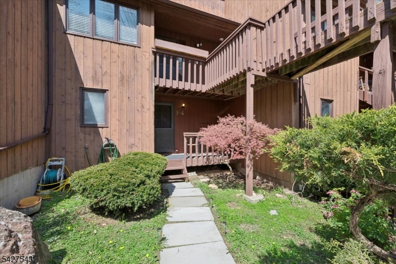 Hidden retreat awaits in sought-after Hidden Village, where every day feels like a getaway. Perfectly positioned just minutes from Mountain Creek Ski Resort, waterpark, bike park, Minerals Spa and Golf, the Appalachian Trail Boardwalk, and The Farm at Glenwood Mountain, this location is a dream for outdoor enthusiasts and lifestyle seekers alike. Less than 15 minutes away, charming Warwick offers a historic downtown, boutique shops, restaurants, Warwick Valley Winery, Pennings Farm Market & Cidery, and a classic drive-in movie theater. Relax on the front porch, perfect for enjoying the natural surroundings, then enter into a welcoming foyer with a coat closet. The main level features an open dining area and kitchen, along with a full bath and convenient in-unit laundry. A short set of stairs leads up to the spacious bedroom with a storage closet, while a few steps down brings you to the airy family room, highlighted by a wood-burning fireplace, dramatic double-height ceiling, and sliding doors to a private balcony. Down one more level, a large, finished basement offers valuable flexible space for a rec room, home office, guest area, or additional storage. HOA fee includes water, sewer, garbage, and snow removal, adding everyday ease and value to this inviting Hidden Village home.
