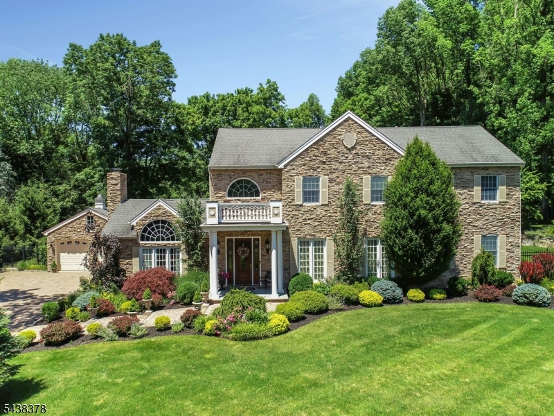 Stately Colonial on one private acre nestled on a beautifully landscaped property, this exceptional 4 bedroom, 4.5-bath home offers timeless elegance, superior craftsmanship, and modern luxury throughout. The gracious interior features impressive 10-foot ceilings on the first floor as well as the primary suite and 9-foot ceilings on the second floor, creating a bright and spacious atmosphere. Hardwood floors run throughout the home, complementing the architectural details and thoughtful design. At the heart of the home is a spectacular family room with custom mahogany built-ins and a gas fireplace, providing the perfect setting for both everyday living and entertaining. The gourmet chef's kitchen is designed to impress, featuring a large center island, beautiful travertine flooring, and top-of-the-line appliances. The luxurious living spaces flow seamlessly to the outdoor entertaining areas, where you'll find a built-in gas grill, outdoor refrigerator, ideal for al fresco dining and gatherings. Additional premium amenities include a whole-house generator, sprinkler system, and a heated two-car garage for year-round comfort and convenience. The exterior is equally impressive, showcasing a paver driveway, patio, & walkways that enhance the home's curb appeal and outdoor living experience. Combining classic Colonial charm with exceptional amenities and meticulous attention to detail, this remarkable residence offers an unparalleled lifestyle in a private and picturesque setting.