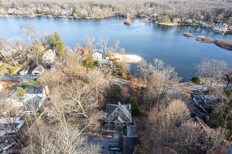 Picturesque Location on OVER 1 acre in beautiful Cedar Lake! Sitting on top of a corner property with LAKE VIEWS AND direct LAKEFRONT access. Great floorplan, design, features & numerous windows to create bright living space. First floor layout includes a large, open eat in kitchen with center island. Lovely "lake style  living room with wood shiplap, light knotty pine, exposed beams & a stone-faced fireplace. Front porch/den is surrounded with windows which could overlook the Cedar Lake views from the front. Office, full bath and laundry room complete this floor. Hardwood floors throughout. Upstairs, 4 generous sized bdrms & full bath, including the primary bdrm with cathedral ceilings, palladian windows & an oversized walk-in closet. Full unfinished BSMT- great for storage in addition to the detached 2.5 car garage. Charming wrap around porch. Perfect layout for entertaining or just everyday living. Make this home yours! Desirable neighborhood and Cedar Lake community. Beaches, fishing, boating, etc. Just a stones throw from Main Beach & Boat Docks. Add your own dock on your very own property. Easy access to DWTN Denville, major highways & NYC Direct Mass Transit. TONS of Shopping & Restaurants Nearby. Public utilities (Gas on street). -- Also includes lakefront property at 38 Cedar Lake W. (Block 60906 & Lot 32)