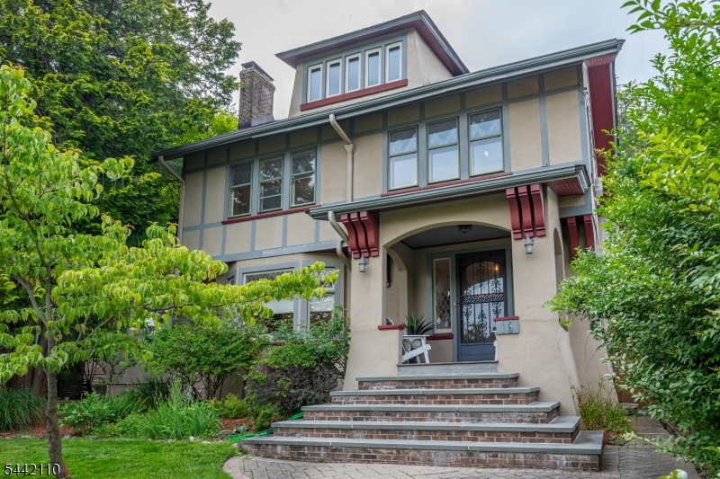 Set on one of Montclair's most exclusive and sought-after streets, this five-bedroom, three-bath residence is a masterful expression of architectural heritage, timeless craftsmanship, and refined living. Ideally positioned just moments from Montclair's vibrant downtown, acclaimed restaurants, cultural attractions, and direct NYC transportation. A stunning entry foyer introduces interiors of remarkable scale and elegance. Rich in character and architectural significance, the home showcases beautifully preserved original woodwork, jewel-toned stained glass, grand coffered ceilings, and exquisite parquet hardwood flooring with decorative border inlays, creating an atmosphere of timeless sophistication. Throughout, museum-quality millwork, artisan-crafted detailing, and heirloom-quality finishes celebrate the home's enduring craftsmanship and historic integrity. The formal living and dining rooms are distinguished by their impressive proportions, abundant natural light, and architecturally significant details. A versatile first-floor room offers flexibility and may serve as a tv room, guest suite, private office, or first-floor bedroom. The upper levels continue the home's legacy of elegance. The expansive primary suite is a true retreat, featuring generous dimensions, a charming fireplace, and serene views. Two additional bedrooms on this level. Occupying the third floor, a secondary primary suite includes a walk-in closet and full bath.