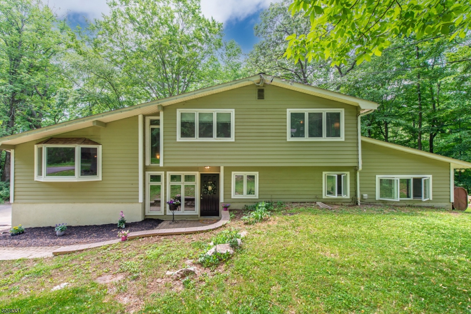 Custom contemporary style, open floor plan with hardwood flooring throughout, soaring ceilings, updated granite kitchen, updated bathrooms, thermal pane windows throughout, 2 decks, generator hookup, family room with fireplace, office with 1/2 bath on walk-in first level, as well as conservatory. Home is on private paved road, lot is very low maintenance, mostly wooded with babbling stream, perfect relaxation! New septic and well in 2016. Close to Rts. 206, 24, 80 and 46. Cucinella Elementary School and West Morris High School.