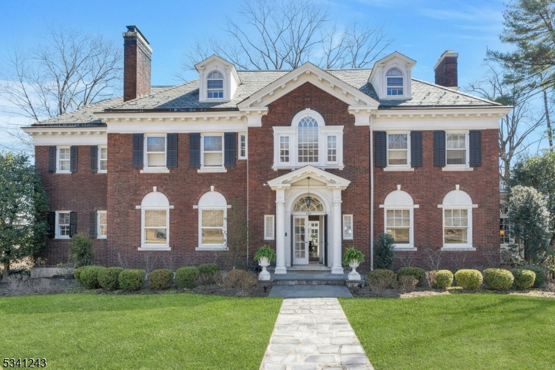 Stunning historic brick Georgian built in 1915 by Abraham Lincoln Burbank! Elegant, stately exterior of this 5BR 4.2BA estate leads way to a warm and inviting interior, flooded with natural light. Original architectural details- picture & triple crown moldings, 11ft. ceilings, 5 fireplaces, leaded glass & Palladian windows add distinction to this home that blend seamlessly with its contemporary finishes- perfect for entertaining & comfortable living. 1st floor boasts a grand entry staircase, gleaming quarter sawn oak floors, bright and spacious dining and living room w/ marble & soapstone fireplace, large, updated EIK w/ pantry, lovely sunroom, library w/ crafted millwork w/ French doors leading to terrace overlooking manicured yard. 2nd floor features expansive primary suite & dressing room w/ new white oak floors throughout, spa bath, 2 additional large BR w/CC closets & adjoining bath, office w/custom oak shelving w/secret door, & solarium. 3rd floor offers two large, sunny bedrooms w/ full baths & cedar storage. Numerous upgrades including newly finished lower-level rec room w/built in entertainment ctr & storage, full gym room & craft room w/ walkout to bluestone patios, firepit area & playground, underground sprinklers, CAC, EV charging station, 2 car garage w/ loft (possible studio apt.) Seasonal views of NYC sunrise & glittering skyline! Ideally located minutes away from vibrant Upper Montclair & Watchung Plaza shops & restaurants, parks and NYC train station.