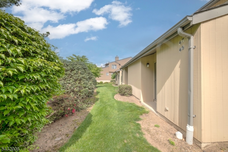 Nestled within the serene and centrally located Scenic Hill community, this meticulously redesigned 2-bedroom, 1.5-bathroom townhome offers a sophisticated sanctuary for the discerning buyer. Luxury and functionality merge seamlessly, beginning at the private entrance which features direct-from-garage access into the first-floor unit. Natural light floods the open-concept living space, highlighting the home's airy proportions. The chef's kitchen boasts premium appliances, elegant quartz countertops, and custom cabinetry, along with a breakfast bar that transitions gracefully into the living room (featuring a gas fireplace) and the dining room, which looks out onto the covered outdoor deck. Downstairs, the peaceful lower-level primary bedroom retreat offers an idyllic indoor-outdoor lifestyle with direct walk-out access to a backyard area and the community's beautiful walking paths. Amenities include a community pool, fitness center, tennis courts, club house with a lounge and walking path. Located with unparalleled proximity to Cooperman Barnabas Hospital, commuter lines to NYC, fine dining, and major thoroughfares, this property represents suburban luxury at its finest.
