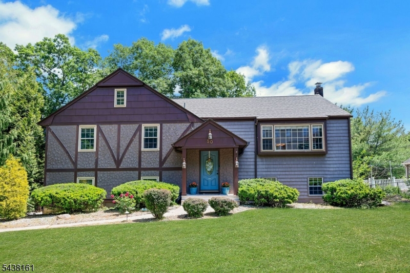 Begin your next chapter in this charming tudor-inspired bi-level home, ideally situated on a coveted 100' x 165' lot in one of the area's most desirable neighborhoods. A level driveway and spacious two-car garage provide a welcoming arrival. Step onto the inviting covered front porch and into a warm, expansive living room designed for both everyday living and entertaining. The sun-filled eat-in kitchen and formal dining room feature sliding glass doors that bring in abundant natural light and create a seamless connection to the outdoor living spaces. This well-maintained home offers four generously sized bedrooms, hardwood flooring, and two-and-a-half updated bathrooms. The ground-level family room is highlighted by extensive sliding glass doors that open to a sprawling patio and in-ground pool. The spacious deck greets the sunrise overlooking the pool and fenced in backyard. The serene outdoor setting provides the perfect blend for relaxing, entertaining, or simply enjoying the peaceful surroundings. This home is also close to premier shopping, dining, and major highways. Just unpack and enjoy everything this delightful home has to offer!