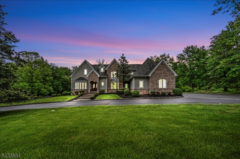 Nestled in a serene & highly private setting, this exceptional custom Colonial uniquely fronts & backs onto protected forest & preserved Green Acres, offering rare privacy & beautiful year-round natural views. Ideally located with easy access to Routes 287, 78, and 22, this home combines peaceful surroundings with excellent commuting convenience. Set on a beautifully landscaped lot, this custom-built home features 5 bedrooms, 4 full baths, & 2 half baths, showcasing timeless architecture, luxurious modern living, & exceptional craftsmanship throughout. A dramatic entry opens to sun-filled interiors with wide-plank hardwood floors, custom millwork, oversized windows, & elegant architectural details. The gourmet chef's kitchen is designed for both everyday living & entertaining, featuring an oversized Viking range, Sub-Zero refrigerator, 2 dishwashers, custom cabinetry, & a large center island flowing seamlessly into the impressive family room with soaring ceilings, floor-to-ceiling stone fireplace, custom built-ins, & walls of windows overlooking the backyard. Formal living & dining rooms, dual staircases, & multiple gathering spaces offer sophistication & functionality. Upstairs, generously sized bedrooms include a luxurious primary suite with spa-inspired bath & expansive walk-in closets, plus Jack-and-Jill & en-suite accommodations. Outdoor living shines with an expansive bluestone patio, heated 3-car garage, & circular driveway completing this remarkable offering.