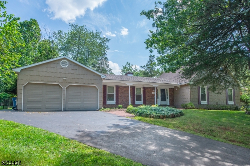 This fantastic colonial style expanded ranch offers five bedrooms, including a first-floor primary suite with a full bath. The partially finished basement provides extra space for your needs. Outside, you'll find beautifully maintained perennial gardens in a great neighborhood. The house is conveniently located near shopping, dining, major arteries like Routes 287, 22, and 78 making commuting a breeze, along with the ability to make quick day trips to the Jersey Shore. The brick fireplace, hardwood floors and recessed lighting add to the charm. The kitchen features newer upgrades like granite countertops and a subway tile backsplash. With public utilities and natural gas, you'll enjoy ease and efficiency. The level yard is perfect for outdoor activities.  French doors lead to the three-season room, complete with a dry bar and door to the backyard;  an ideal space for entertaining. This home is move-in ready with updated kitchen and baths, so you won't have to lift a finger. It's a dream come true!