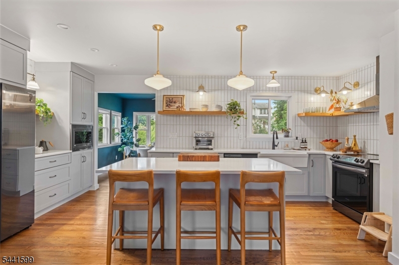 Welcome to this beautifully reimagined split-level home, where modern design and everyday comfort come together seamlessly. Renovated in 2021, this light-filled residence features an open-concept main level with a spacious living room, a sun-drenched dining area surrounded by windows, and a show-stopping custom kitchen with quartz countertops, custom cabinetry, an integrated coffee bar, built-in microwave, pull-out storage, full pantry, designer tile work, and curated lighting throughout. Upstairs offers three generously sized bedrooms and a beautifully updated full bath. The ground level features a welcoming family room, powder room, laundry area, garage access, and a versatile Florida room overlooking the backyard. An unfinished basement provides excellent storage and future potential. Major updates include refinished hardwood floors, a renovated lower level, all new windows, updated plumbing and electrical systems, 200-amp service, newer HVAC and furnace, hot water heater (2024), solar panels with transferable warranties, and a Level 2 EV charger.Enjoy a beautifully landscaped outdoor space complete with hardscaping, fencing, in-ground irrigation, and a widened driveway for two vehicles. Tucked away on a quiet, low-traffic street near the end of the block, this exceptional property offers a peaceful setting while remaining close to shopping, major roadways, and NYC transportation. Truly a must see!