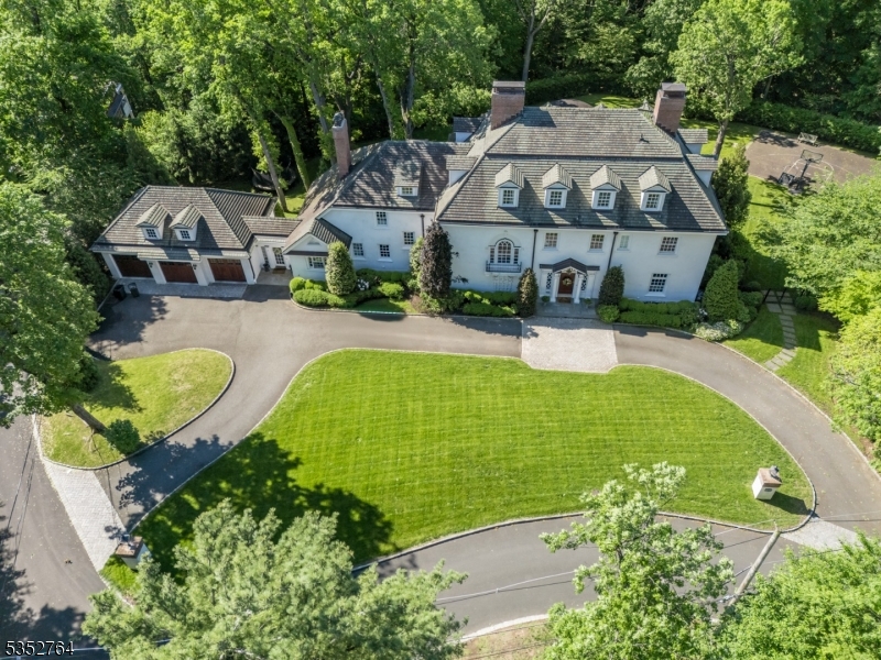 MASTERFULLY RESTORED HOME ON OVER AN ACRE, LESS THAN A MILE FROM DOWNTOWN SUMMIT! Welcome to 10 Rowan Rd, a stately circa 1910 Georgian Colonial w/ over 11,000 sq feet across 4 levels and including 8 Bedrooms/6.1 Baths, minutes from vibrant downtown Summit and NYC train. Exceptional privacy, backing onto Watchung Reservation w/ views of NYC skyline. Originally built by Philip Van Renssalaer Van Wyck and later owned by Adolph Root of Roots Department Store, a complete restoration has upheld its original charm w/ high-end touches to perfectly suit today's lifestyle. Impressive Grand Foyer sets tone for the First Level, rich hardwood floors, fluted columns, stacked crown molding, wainscoting, built-ins and impeccably restored windows. 11 fireplaces overall, each with a unique original mantle. Foyer, Great Room and Dining Room open to spacious Solarium w/ views of landscaped grounds with stone terraces, outdoor kitchen, and sports court. Dream gourmet Eat-in Kitchen w/ massive island, custom cabinetry, marble countertops, SS high-end appliances, 2 complete prep stations. Walk-in Pantry, Laundry & Mud Rooms, Wine Room, 3-Car carriage-house Garage meeting all needs. Sprawling Primary Wing offers Bedroom, 2 Baths, Sitting Room, 2 Walk-in Closets & bonus room. Additional 3 Beds/2 Baths. Third Level has 3 more Beds, 1 Bath & more. Lower Level stuns w/ Lounge, Gym, Recovery Room, Rec areas & Full Bath. This exceptional historic masterpiece is a must-see for today's discerning buyer!