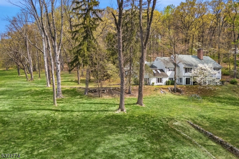 An extraordinary opportunity! Set on ten private, picturesque acres in the heart of prestigious Far Hills, this exceptional property offers an ideal canvas for renovation or new construction. This captivating property is bordered by preserved land and enhanced by a babbling brook, rolling lawns, mature trees, and serene woodlands. The existing Cape Cod-style home features an expansive great room with a fireplace, a first-floor primary suite, and a daylight walk-out lower level with three additional bedrooms, living areas, and a kitchenette. The unmatched setting is one of privacy and tranquility, yet just moments from the charming village center, nationally ranked golf courses, equestrian facilities, NJ Transit, and convenient access to Manhattan. Shopping, dining and recreational opportunities abound in the area. A rare chance to create your vision in one of New Jersey's most sought-after locations.