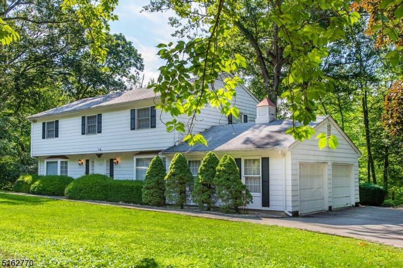 Special Find! Custom Colonial w/Circular driveway near the Rockaway RIver Country Club. Just on the border of Mountain Lakes. Gorgeous, wooded, park Like Setting, Level .95 Acre Property. Gift wrapped in Landscaping- lawn, perennials, mature trees, deck & pond just waiting to be refreshed and refilled. Many rooms to accommodate a versatile lifestyle; handsome entertaining space. Eat in kitchen w/Pantry, Mud & Laundry Rooms conveniently located off the 2 car garage. Fabulous brick WB fireplace in cozy family room- wood paneling, windows & wet bar closet. Large formal dining & living rooms bookend the foyer. Make it your own! Numerous features to fall in love with. Vintage Details, Chandeliers, Large Bay Windows. Upstairs 3 generous sized bedrooms w/large closets, bath w/double vanity plus oversized Primary w/cedar walk-in closet & en-suite. All this but still saving the best for last.. bsmt hosts a full Pub, Billiards room & large workshop. Rounded corners & wooden paneling give it that extra dose of uniqueness. All thoughtfully constructed, designed, customized & cared for by the Original Owners. Spacious & Gentile inside & out. Perfect for entertaining! Ideal location near mass transit, highways, shopping and schools. (2 car garage can be expanded to 3- the concrete pad for 3 cars was included in the original design & is adjacent to the current garage)