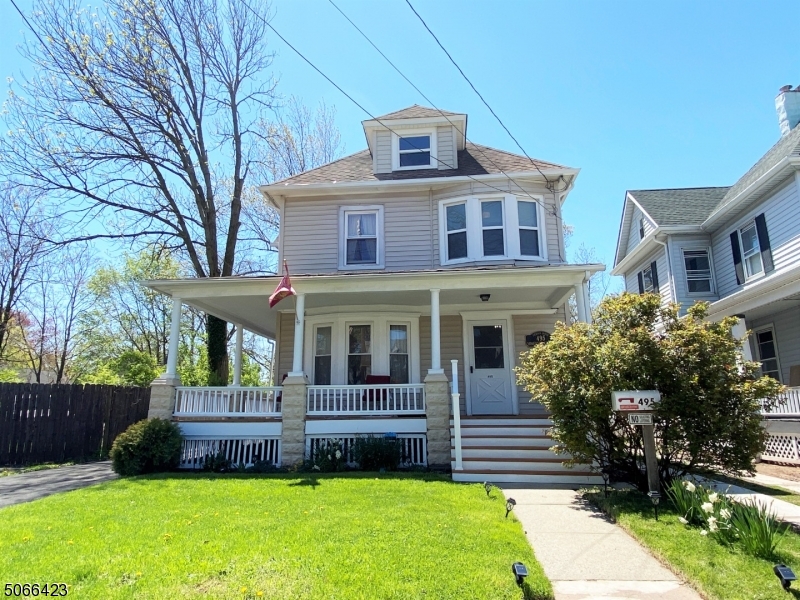 A wrap-around porch welcomes you to this freshly painted Colonial updated in 2020 w/refinished hardwood floors throughout, new bath & lighting fixtures, ceiling fans & newly paved driveway. First floor features high ceilings, an eat-in kitchen w/breakfast bar, a bedroom (formerly a dining room) and en suite bath w/walk-in shower. Bedroom can be easily restored to a dining room if you prefer. Large bay window fills the living room w/great natural sunlight. Second floor has 3 bedrooms, a den w/bay window & full bath w/tub/shower. Walk-up attic w/3 windows is an amazing additional space. Full, unfinished basement has Bilco door for easy access to the yard & detached garage. Plenty of storage space! Short distance to town, restaurants, shopping, NJ Transit bus/train to NYC & major highways.