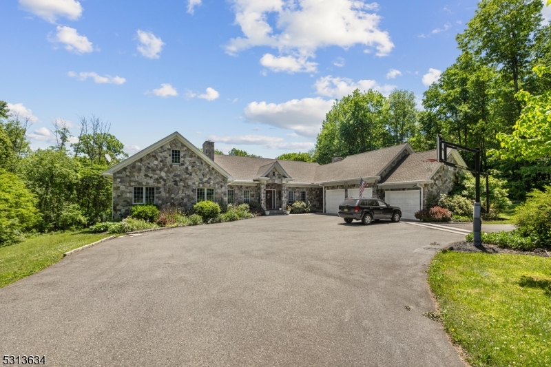 Welcome home to this secluded custom built ranch home. This home was crafted by a master stonemason who has lived here with for 30 years. The main floor of this home features a great room with cathedral ceilings and a stone, wood burning fireplace.  Modern kitchen with oversized granite island  and breakfast nook which opens onto one of the brick patios. The formal living and dining rooms are spacious enough to accommodate everyone. Custom built cabinetry and a second wood burning fireplace. The primary bedroom is spacious and. Features two walk in closets. The primary bath has a shower stall and jetted tub. There are three additional bedrooms on this floor  and a study. Two more full baths and a full sized laundry and butlers pantry. The basement is finished with another wood burning fireplace, a full sized wet bar, Billiard room, media room and a wine cellar. The basement opens to a second brick patio. This home sits on 2.5 acres but is surrounded by 11 acres of environmentally protected woodlands. All structural and mechanical systems have been maintained to the highest degree.