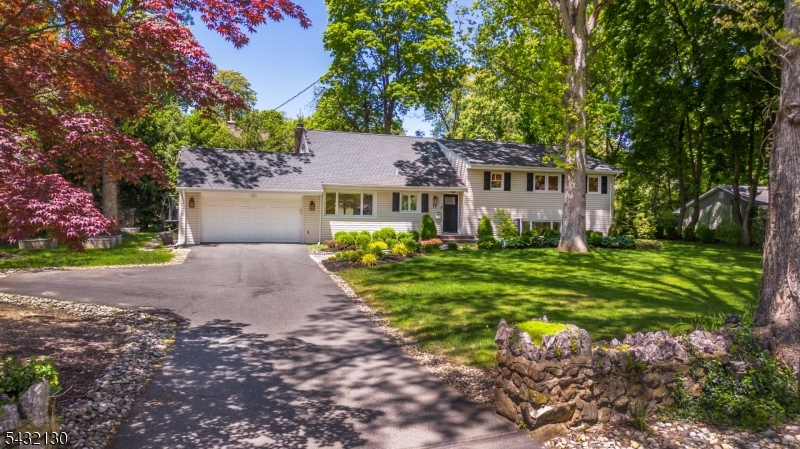 Experience the perfect blend of modern luxury and small-town charm in the heart of Mountain Lakes. Set on a pristine, level .36-acre lot framed by signature stone walls, this meticulously updated custom home offers a lifestyle of effortless elegance. The open-concept main level is anchored by a gourmet chef's kitchen featuring sleek quartz countertops, stainless appliances and a sun-drenched breakfast bar that flows naturally into the dining area. Relax in the expansive living room by the wood-burning fireplace, or escape to the sanctuary of the glass-walled sunroom with its rustic stone flooring. The primary suite serves as a bright, spacious retreat with a walk-in closet and skylit ensuite bath. Two additional modern bedrooms and a flexible fourth bedroom ideal for a home office or media room ensure plenty of space for everyone. The lower level is a true extension of the home, featuring a light-filled recreation room, newer full bath, and laundry room. Life in Mountain Lakes is all about the outdoors. Spend your evenings dining alfresco on the patio or gathering around the stone fire pit. With high-end upgrades including a newer roof, AC handler/heat pump, enhanced insulation, and an electric car charger, the work is already done. You're just steps from top-tier schools, local fields, and the serene lakes that define this premier community. Moving in is the only thing left on your to-do list. Special financing incentives avail on this property from Sirva Mortgage.