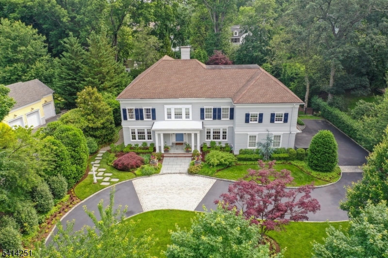 Welcome to this exceptional Custom Colonial in Summit's coveted Northside neighborhood, just a short walk to downtown Summit, the train and Lincoln Hubbard Elementary School. Extensively renovated in 2018, this magnificent 6 bedroom, 5.2 bath home boasts three levels of refined living on a pristine, level .74 acre property with beautifully manicured grounds. The sun-filled first floor showcases fine craftsmanship with custom cabinetry, solid wood moldings, and hardwood flooring throughout. A welcoming foyer leads to a gracious living room with gas fireplace, sun-filled den and elegant dining room. The open concept family room with gas fireplace flows seamlessly into a casual dining area and gourmet eat in kitchen featuring a center island and premium appliances. A well appointed pantry and mudroom add exceptional functionality with a second refrigerator, wet bar, and full height wine refrigerator. French doors open to an idyllic backyard oasis featuring a bluestone patio, spacious wood deck, heated in-ground plunge pool, gas fire pit, mature landscaping, in-ground sprinklers and top tier landscape lighting. Upstairs, the luxurious primary suite offers a spa-like bath and abundant closet space. The fully finished basement includes a spacious home gym and laundry room with chute access. Additional features include a whole home generator, built-in speakers, Lynx natural gas grill, and Smart 3 zone HVAC systems. This is the very best of vibrant Summit living!