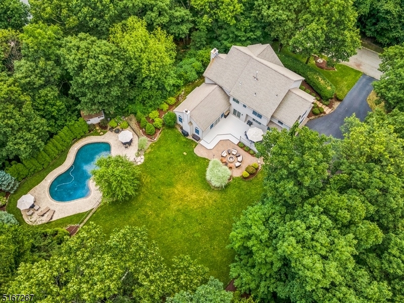 Stunning custom Colonial is situated in the enviable Ridge Run neighborhood of Kinnelon. Nestled on a 1ac+ lot on a peaceful cul-de-sac, this home is only 35mi to NYC & close to top-rated schools, shops, rest, major hways & parks. The generous rm sizes & an open flow layout are ideal for entert w/rich hardwood flrs, raised panel wainscoting & crown molding & an abundance of natural lighting throughout. The everyday living & entert spaces flow outside to the large deck, stone paver patio & free-form in ground heated pool in the beautifully & landscaped backyard. A welcoming stone paver entry invites you inside to a 2-story foyer, formal DR, LR, & a large FR w/a wood burning firepl. French doors open to a spacious great rm w/a dramatic vaulted & wood paneled ceiling, a massive stone-surround firepl, wet bar, expansive window views & access to the deck. The spectacular open kitchen is elegantly appointed w/granite counters, custom cabinetry, center island, WI-pantry & a butler's pantry connecting to the DR. Sliding glass doors in the sunny breakfast nook open to the deck & patio w/a built-in fire pit. A first flr, full bth, laundry rm, study/media rm & a bd currently used as an office complete the this flr. The 2nd flr incl a spacious primary bd suite w/a vaulted ceiling, WIC & en suite bth w/a jetted tub & dual vanities. 3 addt'l bds, 2 w/WIC, all share a hall bth. The finished basem lev offers a rec-room, half bth, a bonus rm, access to the garage, & plenty of storage space.