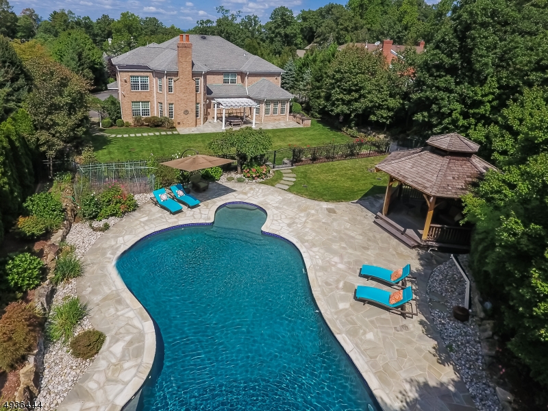Spectacular Custom All Brick Center Hall Colonial ideally located on prestigious street on .71 acres of stunning park-like property with a gorgeous salt water pool. Designed w/ Feng Shui principles. This stunning home features a grand entrance hall with 20' ceilings, a stunning gourmet kitchen, 2 fireplaces, and a luxurious master bedroom suite w/ sitting room, 2 walk-in closets, & a spa-like master Bath. 9' ceilings on the 1st & 2nd levels. The lower level features an incredible recreation room w/ large wet bar & karaoke sound system, a Billiard room, full bath, & a state of the art Home Theatre with leather seating for 8. Walk one block to highly rated Deerfield Elementary School. Replacement cost would be 4,000,000! Bus service available to Millburn Middle & High schools. Tax appeal owner won!