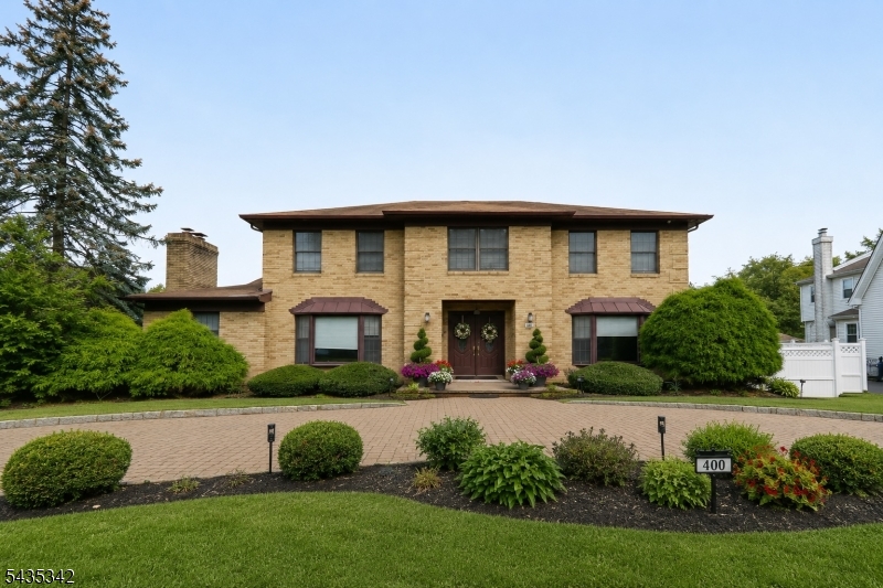 Spacious, beautifully maintained, this impressive 5-bedroom, 3.5-bath home offers over 4,400 square feet of versatile living space excluding the garage. The double front entry doors, paver horseshoe driveway, and  landscaped property create outstanding curb appeal. Inside, you'll find oversized rooms, hardwood floors & crown molding throughout the first floor, recessed lighting, and an ideal layout for comfortable living. The spacious kitchen features granite countertops, solid cherry wood cabinetry, a bar area, and abundant storage and prep space. Bay windows throughout the home bring in beautiful natural light and add charm. The second floor offers 4 generously sized bedrooms, all with double closets. The primary suite includes private bath and a walk-in closet. The finished walk-out ground level provides flexibility with a second kitchen, office/bedroom full bathroom, storage space, and direct access to the backyard perfect for extended living, entertaining, or guest accommodations. Private backyard retreat featuring a heated saltwater pool, hot tub, covered patio with deck above, fenced yard, two sheds, and mature landscaping designed for relaxation and enjoyment. Additional highlights include a 2-car garage, first-floor laundry room, pull-down attic access, two coat closets, 2 Zone central air and efficient 5-zone baseboard heating. A rare opportunity offering space, functionality, and resort-style outdoor living all in one exceptional property.