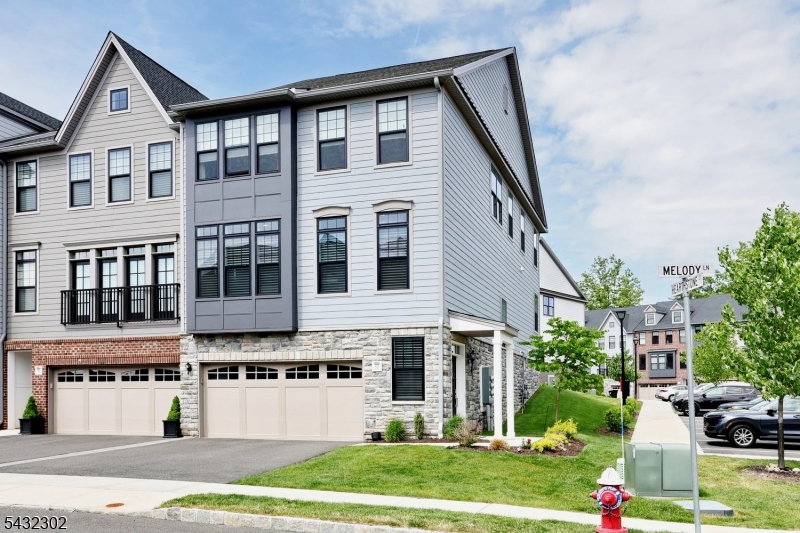 Welcome to the Grove at USR. Experience luxury living in this beautifully maintained End-Unit townhouse offering the perfect blend of style, comfort and convenience. Featuring 3 bedrooms, 2 full baths and 2 half baths, this well designed home showcases modern open-concept living with exceptional space for both everyday living and entertaining. The sun-filled main level features hardwood floors throughout, an inviting open layout centered around a designer eat-in kitchen with a large center island, beverage refrigerator, upgraded cabinetry, quartz counters ideal for gatherings and casual dining. Sliding glass door leads to a private deck, creating seamless indoor-outdoor living. The spacious dining area flows into the elegant great room with a gas stone fireplace. A convenient powder room completes the main floor. Upstairs, the luxurious primary suite offers a large walk-in closet and a spa-inspired bath with double sinks and upscale finishes. 2 additional bedrooms, a full main bath with double sinks and laundry room. The ground level offers additional living space with a versatile family room, half bath and direct access to 2-car garage. Enjoy resort style amenities including pool, clubhouse, gym and community room. Conveniently located near shopping, restaurants, parks, train and bus transportation. Top rated schools.  Ideal for todays lifestyle and entertaining.