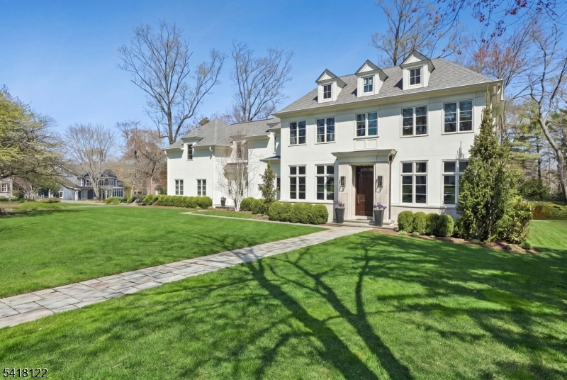 MAGNIFICENT CUSTOM, MODERN COLONIAL * Designed by J.Paragano AIA and set atop exquisitely landscaped property in one of Short Hills' most prestigious enclaves, this sophisticated home has an easy-flowing floor plan and showcases exceptional design, bespoke craftsmanship, refined finishes & unparalleled attention to every detail. Stately facade & gracious, front-to-back foyer open to elegant, sun-filled formal rooms. A dramatic double-sided, gas fireplace anchors the DR while the LR and sunroom or 1st flr office feature oversized windows & French doors for an abundance of natural light. Show-stopping kitchen features Varenna by Poliform cabinetry, top-tier appliances (La Cornue/Gaggenau/Sub-Zero/ two Miele dishwashers), center island w/ bar seating, Butler's pantry & deluxe mudroom. The adj family room w/ marble fireplace and breakfast rm w/ floor-to-ceiling doors create seamless indoor-outdoor living. Upstairs: lg laundry room, five bedrooms, four sparkling baths, including a luxurious primary suite w/ two WICs & spa-like marble bath. Finished LL: 6th BR, full bath, rec room, office & fitness rm. Step outside & prepare to be WOW-ed by the Bluestone patio & covered loggia that overlook beautifully landscaped, private grounds (room for pool!). MORE: oak flrs, Visual Comfort lighting, dog fence, Sonos, freshly painted intr & ext, 3-car garage. Chic, sophisticated & timeless 38 Deer Path is a rare opportunity to own a legacy property in the heart of Short Hills. Welcome home.