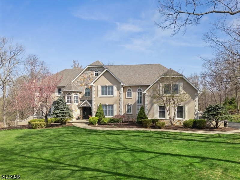 Elegant and grand inside and out, this exceptional residence in sought-after Sussex Mills offers refined living at its finest. Masterful design and modern luxury define this spacious Colonial is set on nearly 2 acres of private, park-like property. The interior showcases generous room sizes, elegant architectural details, and hardwood floors throughout. Expansive entertaining spaces extend outdoors to a large deck and heated saltwater pool with a beautifully designed patio, perfect for gathering, dining, and relaxing in a serene setting. A dramatic 2-story foyer opens to a formal dining room with butler's pantry, living room, a 1st-floor bedroom with en-suite, and a stunning family room with fireplace and a 2-story wall of windows. The chef's kitchen features white cabinetry, ample counter space, an oversized island, high-end appliances, and a bright breakfast nook, with sliding doors leading to the deck. A powder room, pantry, and mudroom/laundry and garage access complete the main level. Upstairs, the primary suite offers a sitting area with fireplace, spacious walk-in closet, and spa-like bath with dual vanities and a jetted tub. 3 additional bedrooms include 2 with en-suite baths and generous closets. The finished walkout basement includes a rec room, game room, bonus space, full bath, and storage. A 2-zone geothermal system adds efficiency. Perfectly positioned, easy access to year-round recreation, close to Rt15, I-80, and nearby charming downtowns.