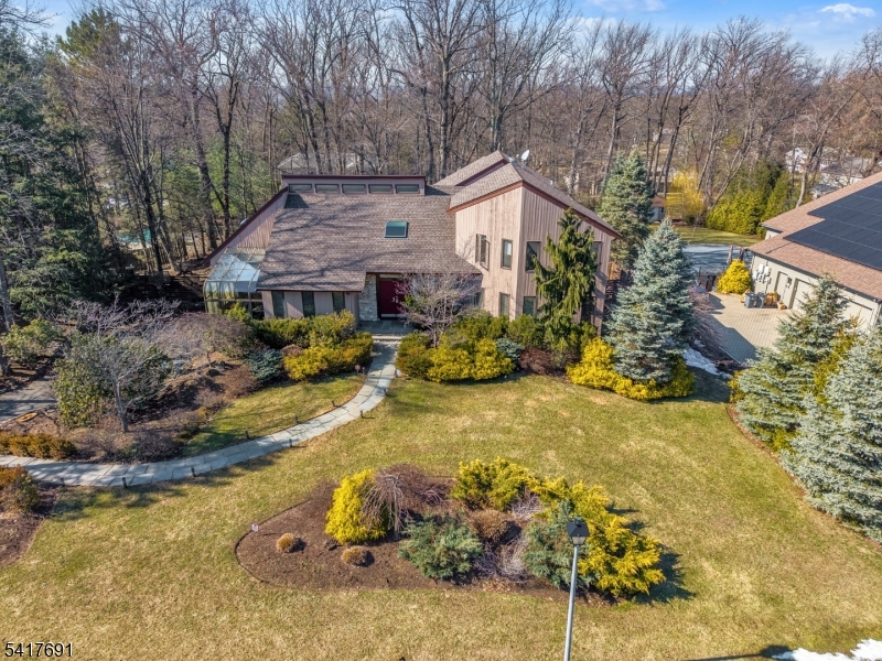 Dramatic, bright, and beautifully renovated contemporary home set on one of North Caldwell's most sought-after streets. This modern 5 bedroom, 3.5 bathroom residence offers a light-filled, open and airy layout with soaring ceilings, skylights, and expansive windows throughout. The spacious great room features a striking stone fireplace and seamless access to the expansive two-tier deck, ideal for indoor/outdoor entertaining. The newly renovated kitchen with huge center island, SS appliances, and quartz countertops is complemented by a stunning glass-enclosed atrium, creating a truly unique and sun-drenched space enjoyed year-round. The main level features a generous primary suite with dressing area, 2 walk-in closets, and a spa-like bath with jacuzzi tub and stall shower, along with another bedroom and convenient first-floor laundry. Upstairs offers three additional bedrooms. The amazing and fully finished basement includes a large recreation space plus bonus sauna room! Set on a beautifully landscaped large property with mature plantings, the private backyard offers multiple outdoor living areas and exceptional tranquility. Complete with a 2-car garage and long driveway. Located in ultra-desirable North Caldwell, close to top-rated schools, shopping, dining, and parks.