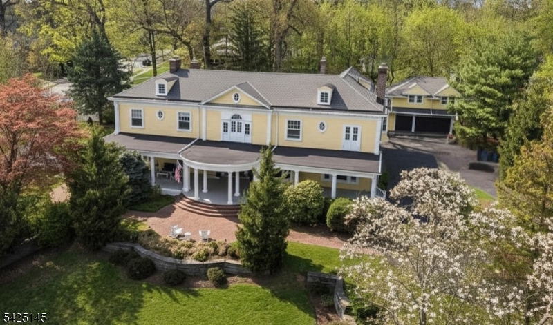Perched atop a hill in the coveted South End with sweeping NYC views, this distinguished 1898 Colonial by noted architect Warrington G. Lawrence offers a rare blend of historic grandeur and modern livability, just blocks from the Midtown Direct train and top-ranked schools. A stately front porch introduces timeless neoclassical and Greek Revival details, including intricate moldings, fine millwork, and five fireplaces, one a striking carved stone replica of the Pergamon Altar. Meticulously restored by its current owners, the home honors its architectural heritage while embracing modern comfort and was awarded the 2017 Glen Ridge Historical Society Preservation Award. Enhancements include a private primary suite, updated kitchen and baths and central air. Inside, a gracious center hall connects expansive, light-filled rooms in a rare open layout for the era. The chef's kitchen features a large island, floor-to-ceiling cabinetry, a full butler's pantry, and a dramatic double-sided fireplace shared with the breakfast room. The kitchen and mudroom open to a bluestone patio and private backyard, ideal for seamless indoor-outdoor living, and connect to a spacious family room. The second floor offers 6+ bedrooms and 3 full baths, including a serene primary suite with fireplace, dressing room, and flexible bonus room. A separate carriage house with a 3+ car garage and 2-bedroom apartment above provides exceptional versatility for rental income, guests, or extended living.