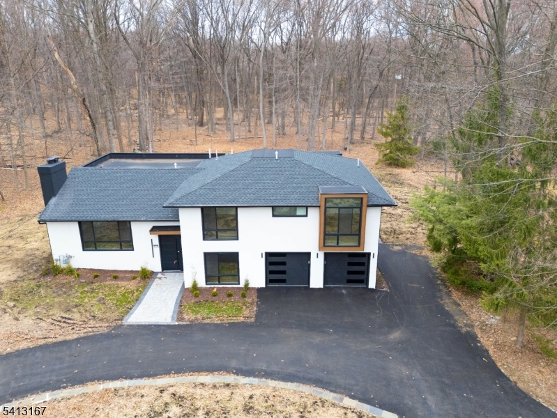 Custom unique expansive & open floor plan on 1. 8 Acres - Dramatic curb appeal from the circular driveway. Modern stucco & techwood vertical siding complements the black 8 ft European steel front door & oversized aluminum windows (coated & with argon for low E). Bright Sunlit Living room with gas fireplace. Home chefs dream KITCHEN - Breakfast area, huge Island, backsplash, cabinets, quartz counters & smart appliances. Dining room with additional seating area & a powder room. Steps down to a Family room. Guest bedroom with a bath on this level, laundry room & access to garage with tiled floors & EV charger. Master bedroom with ensuite & balcony. 2 other bedrooms & bath on this level. Organized closets & bathrooms have Bidets, LED mirrors & towel warmers. Finished LOWER LEVEL offers versatile options for indoor fun.  - Wi-Fi enabled thermostats for 4 zone gas HVAC, exterior lighting, cameras, door openers - hardwired TV outlets & ports. New 5" wide white oak flooring, accent walls, floating stairs, metal railings, solid doors, driveway, 200 Amp electric, insulation (even between floors & walls), plumbing, water softener & hot water heater. 26x12 Trex deck with gas connection for the grill. The incredibly private wooded backyard with no wetlands can host multiple outdoor activities -even tennis or hoops ! City utilities. Minutes to highways, NYC train, schools, shopping & restaurants. Reimagined for personal use & lovingly remodeled with the latest designer features & fixtures.