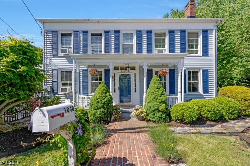 Step inside this charming farmhouse colonial blends timeless character with modern updates, starting with its inviting rocking chair front porch and classic curb appeal. Inside, the main level features soaring 10-foot ceilings and spacious living and dining rooms filled with natural light perfect for everyday living or entertaining. The 2022 updated kitchen shines with quartz countertops, a center island, custom backsplash, high end appliances, and a stunning farmhouse sink. A cozy fireplace with gas hookup adds warmth, while the Dutch door leads to a beautiful screened-in three-season porch ideal for relaxing and enjoying the changing seasons. The main floor also includes a full bath, walk-in pantry, laundry room, mudroom, and back entry closet. Upstairs, the original staircase leads to the sleeping quarters, including a primary bedroom with hardwood floors under carpeting, ceiling fan, and access to a bath with tub and walk-in dressing room. Two additional bedrooms complete the second level. Outside, enjoy a fenced yard with perennial gardens, circular patio, shed, and garage for extra storage. With public utilities and a location in a desirable historic setting, this home offers charm, comfort, and convenience in one special package.