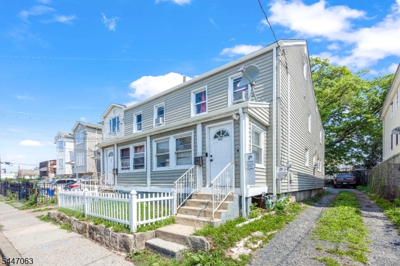 Exceptional side-by-side two-family property offering an outstanding opportunity for investors and owner-occupants alike. Each spacious unit features 4 generously sized bedrooms, providing excellent rental income potential and flexible living arrangements. Each unit welcomes you with a spacious enclosed front porch, perfect for a sitting area, mudroom, or additional seasonal living space. One unit includes the convenience of an in-unit laundry. The property offers separate utilities, a full basement with abundant storage, and two expansive driveways with parking for approximately 10"15 vehicles a rare and highly desirable feature in Elizabeth. The roof was replaced approximately one year ago, providing added value and peace of mind for the new owner. Ideally located near shopping, restaurants, schools, public transportation, major highways, and Newark Liberty International Airport, this property combines convenience with strong investment potential. Whether you're looking to expand your real estate portfolio or live in one unit while generating income from the other, this well-maintained multifamily is a fantastic opportunity in a prime location.