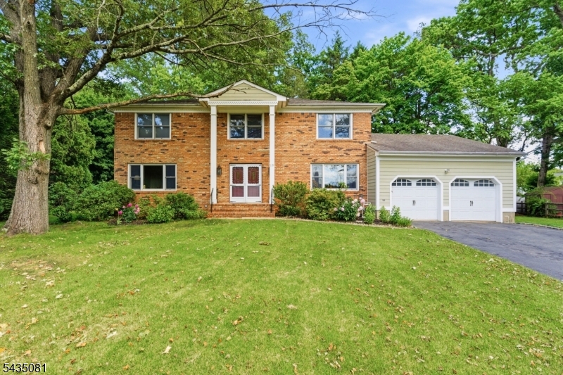 A welcoming double-door entry opens into a grand, sun drenched foyer, setting the tone for this beautifully maintained brick front home featuring premium James Hardie fiber-cement siding, ideally situated on a quiet cul-de-sac. Just a short stroll to Convent Station, this prime location offers easy NYC commuting and everyday convenience. The main level showcases an elegant living room that flows seamlessly into a spacious family room, where sliding glass doors lead to an extra large wood deck spanning the rear of the home, perfect for outdoor dining, entertaining, or relaxing in a serene setting. The updated eat-in kitchen connects effortlessly to the formal dining room, creating an ideal layout for both daily living and hosting. A private first-floor bedroom and convenient laundry room complete this level. Upstairs, you'll find four generously sized bedrooms, including a spacious primary suite with an oversized walk-in closet. Hardwood floors extend throughout much of the home, with additional hardwood preserved beneath the carpeting in select areas, offering the opportunity to reveal more continuous hardwood on both the main and upper levels. The fully finished lower level expands the home's versatility with a dedicated home office, storage room, utility space, and a large open area ideal for a home theater, gym, recreation room, or creative studio. A rare offering that blends space, comfort, and lifestyle in a highly desirable walk-to-train location. FP sold as is.
