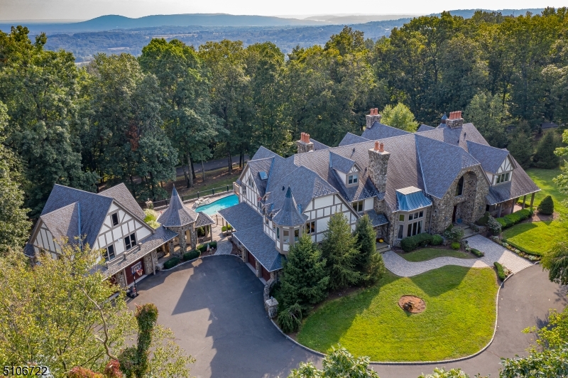 Overlooking some of New Jersey's most scenic countryside, this European-inspired manor is a showcase of superlatives and gracious living. A private road ascends to the manor's 9+ acre setting. An oasis of manicured grounds, lush landscaping & sun-oriented terraces host a free-form pool, spa, & dining enclave with fireplace. The renovated kitchen showcases a coffered ceiling, double-thick granite and quartz counters, custom cabinetry, & robust Sub-Zero and Wolf appliances. The walk-out lower level opens to the pool terrace from the spacious media room. Accompanied by 4 heated garages, 2 attached & 2 detached, the latter with unfinished apartment above, a full house generator, security system, and 8 fireplaces. Located only minutes from major highways, & 35 minutes to Newark Liberty Int'l.