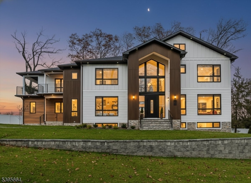 Experience Modern Luxury Redefined in this Stunning Masterpiece, Built and Designed by the renowned NJGCB, an award winning leader in Modern Architecture.  Nestled at the end of a quiet cul-de-sac, this New Construction home offers up both privacy & breathtaking water and golf course views. Thoughtfully designed w/ exceptional craftsmanship, this custom home features 6 beds, 6.1 baths, 3 Car spanning over 6,700 sq ft of finished living space. Grand foyer welcomes you with massive floor to ceiling windows, floating staircase & herringbone HW floors. The heart of this home is your gourmet kitchen, where every element was meticulously crafted.  Professional grade SS appliances, an abundance of sleek custom cabinetry, center island & walk-in Pantry.  Kitchen opens to an impressive 2 story Family Rm w/gas FP, soaring ceilings, skylights & oversized sliding doors leading to outdoor deck, perfect for Entertaining.  Elegant butler's pantry connects kitchen w/ Formal Dining Room, blending luxury with functionality.  A First Floor Guest Suite offers convenience & accessibility.  A beautifully appointed Primary Retreat w/ Covered Balcony, Custom Closets & Spa Inspired Bath w/dual showers & soaking tub. Three additional En Suite Beds & Laundry.  Above Ground walk-out basement, filled with sunlight includes Media Rm, Bedroom, Bath, Gym, Office, Wet Bar & Rec Room. Two sets of Sliding Doors leads to paver patio & fenced in yard w/room & approvals for future pool. Luxury Living at its Best.