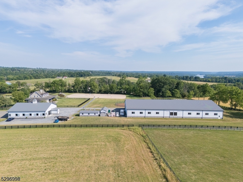Experience the pinnacle of country living. This extraordinary 11+ acre custom estate in Alexandria Township boasts 360° panoramic views of Hunterdon and Bucks County! This property masterfully combines luxury residential design with professional grade horse facilities. The 3228 sq ft, 5 bed, 4 bath colonial was thoughtfully updated in 2021. It features a gourmet kitchen with a large center island, first floor primary suite with luxury bath,plus a junior suite with full bath. The layout includes a formal dining room, office, mudroom w laundry and wood-burning fireplace. Second floor offers 3 bedrooms, bonus room, laundry and full bath. A finished basement with 9 foot ceilings, private outside entrance, full bath and radiant heat serves as a perfect guest retreat. Amenities include whole house generator, multizone HVAC,and a oversized two car garage.  The equestrian facility is unparalleled. The insulated main barn features rubber pavers throughout, 9 stalls with therapeutic mats, fly spray system, camera system, LED lighting, heated tack room, lounge, and office, 2 wash stalls, and 2 tack stalls. Outside there are an additional six stalls with therapeutic mats, wash/tack area, bath and laundry. Training facilities include 80x180 indoor arena with TravelRight dust free footing, and LED lighting, 150x250 outdoor ring with GGT footing, and 70 foot round pen, with TravelRight footing, 9 hotwired paddocks, frost free hydrants, RV hook ups, perimeter bridle path, trails nearby.
