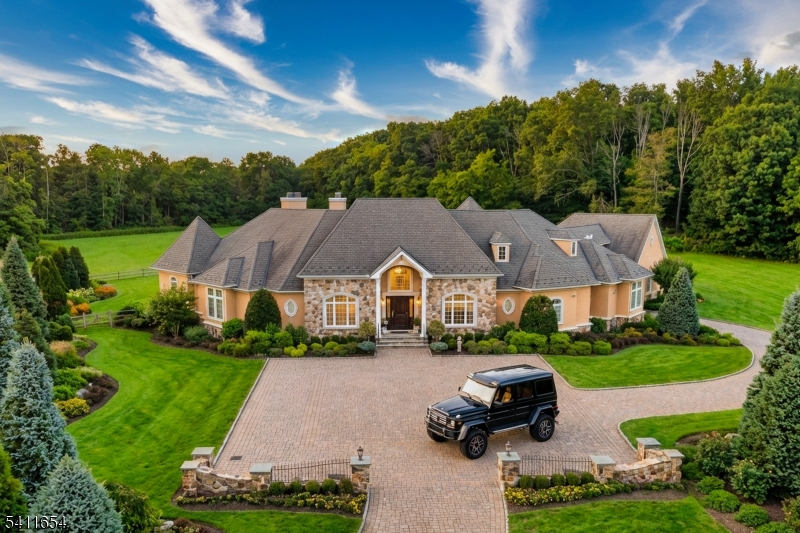 Set down a long private driveway on 6.81 acres, this luxury estate offers privacy and convenience near shopping, dining, and major travel routes. Featuring 5 bedrooms and 7 full and 1 half bathrooms, the open-concept layout showcases 24-foot ceilings, floor-to-ceiling windows, and a marble gas fireplace. The gourmet eat-in kitchen includes a large center island, Clive Christian-inspired cabinetry, granite countertops, high-end appliances, and a butler?s pantry with a wine fridge. The private primary suite offers a fireplace, sitting area, spa-style bath, and custom walk-in closet. Additional highlights include multiple en suite bedrooms, home theater, wine tasting room, custom bar, gym, 2,800+ sq ft storage, and an oversized 4-car garage. Resort-style outdoor living features 4,000+ sq ft of patio space, Pebble Tec pool, spa, fire bowls, and covered entertaining areas.