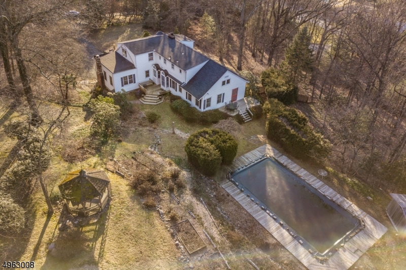 Special Find! Custom Colonial on 3.23 Acres Wooded Knoll of Private, Park-Like Property. Gift wrapped in Landscaping- lawns, colorful perennials, mature trees, gazebo, deck & inground pool. All overlooking Rockaway River Country Clubs prestigious golf course. Grand living inspires elegance through traditional design but has all the major upgrades of a NEW septic, h/w heater, oil tank & roof. Many rooms to accommodate a versatile lifestyle; handsome entertaining space, butlers pantry & library. 2 large, open fireplaces. Lovely vintage details, French doors, wide plank HW flooring, cherry cabinetry, crystal doorknobs- just to name a few! Tons of storage in 2 car garage, attic & full bsmt. Spacious & Gentle inside & out. Ideal location near NYC-direct mass transit, hwys & schools.