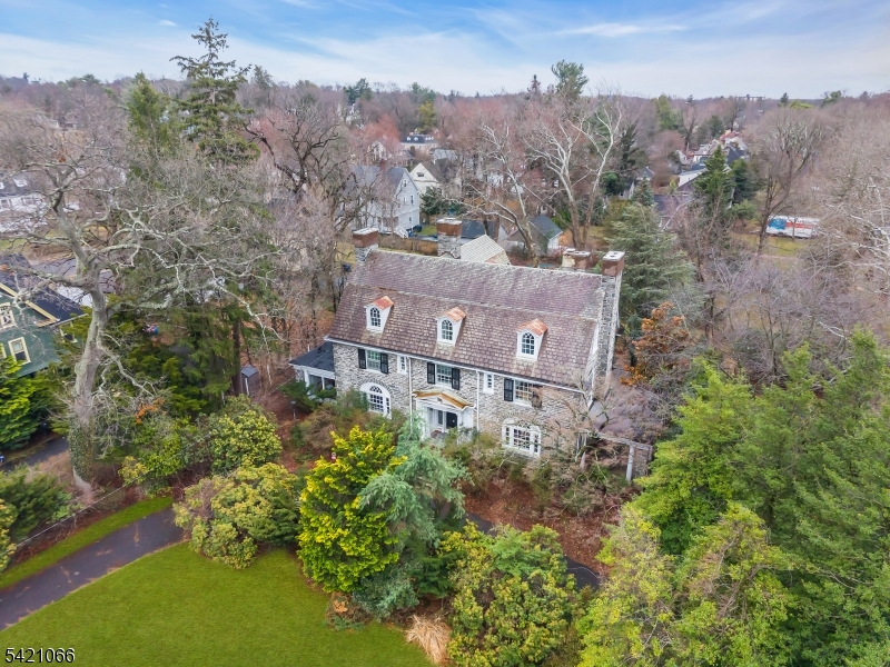 One of Plainfield's finest mica stone mansions built during the Golden Era. Situated on one plus acre with mature plantings. This home boasts of 14 rms, 6 brms, 4 full ba and 2 half ba. A grand three-story captain's staircase welcomes you into a home of impressive scale, featuring 6 beautifully appointed bedrooms and 7 gas/woodburning fireplaces that add warmth and charm throughout. Classic details shine at every turn from rich parquet floors and striking Palladian windows to elegant French doors and custom built-in cabinetry anchoring the formal dining room. 10' ceilings, oversized rooms, many porches & verandas on all 3 stories to enjoy the views. Spectacular chef's kitchen elevates the home's sophistication as a true centerpiece, a large granite island, top of the line appliances, integrated sink, and abundant of cabinets, storage and walk in pantries. Primary suite offers a serene retreat with en-suite bath featuring both a soaking tub and separate shower. A Juliette balcony and an adjoining sitting room/br perfect for relaxation. The third level has beamed ceiling game room, family room both with fpls. There is also access to a terrace, and additional storage. Modern updates complement the home's historic beauty, including a newer water heater, multi-zone heating, updated bathrooms throughout. Enjoy your private oasis with in ground swimming pool and a three-car garage completing this rare offering. Home incudes 1 year home warranty.