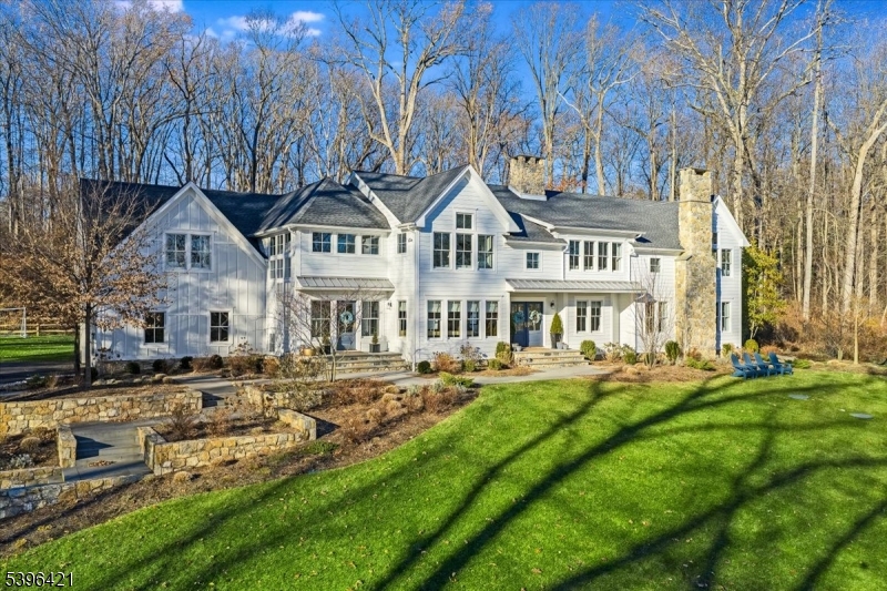 This masterfully re-imagined custom built Farmhouse style Colonial blends classic architecture with refined country living in the coveted town of New Vernon in Harding Township. This re-designed home was completely re-built from the foundation up in 2022. A spacious light filled, comfortable and chic living space has been created containing six en suite bedrooms including a first fl. primary bedroom suite w/ laundry & sitting rm/office.. Dbl. doors open to front foyer. The main gathering areas span from entrance to family room which opens to  great room.This generous space anchored by a stone FP includes custom wet bar cabinet & black steel french doors to terrace. The epicurean kitchen fitted with white oak cabinets, upper end appliances, oversized island & dbl. sided FP. Adjacent are the butlers pantry & mudroom. Cathedral ceiling in rear/side foyer w/ 2 story window and staircase to 2nd floor leads to 4 en suite bedrooms, laundry room and den/game room. Finished generously sized LL contains family room w/wall mounted TV, play area, billiard area, finished room/home office, full bathroom, gym/exercise room  with rubber flooring & wall mounted TV, 3 mechanical rooms/closets. Bluestone terrace on level rear yard with multiple access points from home. Custom built stone wall and steps to front and side entrances.