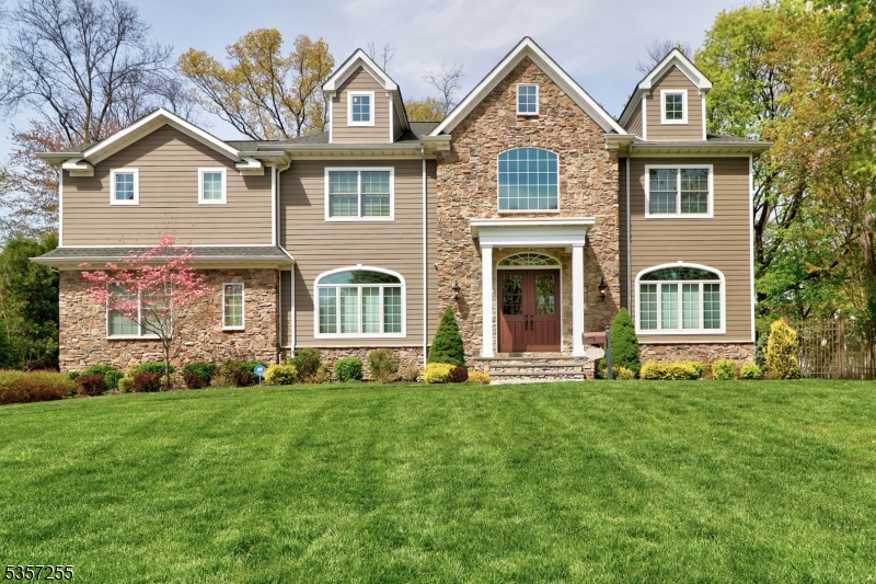 A Showstopper from every angle! This striking residence has been turning heads since the day it was built and it's easy to see why. The stunning curb appeal sets the tone, but it's what's inside that truly impresses. Soaring 10-foot ceilings on the main level, oversized 8-foot doorways, transom windows, and a dramatic two-story foyer create an open, airy feel throughout. The home is richly appointed with detailed millwork, thick moldings, and custom wood finishes that elevate every room. The first floor features formal living and dining rooms, a chef's kitchen overlooking the expansive family room, a butler's pantry, a generous bedroom with ensuite, and a 3-car garage. Head upstairs via the grand staircase or private back stairs to find five more bedrooms, four with private baths (including a Jack and Jill). The luxurious primary suite is its own retreat with tray ceiling, fireplace, sitting room, three closets, and a spa-worthy bath featuring intricate tilework, oversized shower, and soaking tub. The finished basement includes an impressive gym, custom wet bar, and plenty of room to relax or entertain. On the top floor, a sunlit finished bonus level offers flexibility for a home office, playroom, or studio. Step outside to your own private paradise an expansive paver patio and fully fenced yard, perfect for entertaining or quiet outdoor living. Florham Park offers low taxes, a top-notch school system, and is a commuter's delight with easy access to trains and major highways.