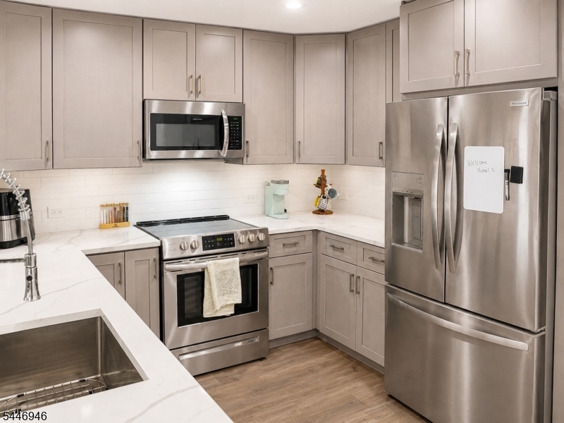 Rarely available corner residence offering one of Skyview's largest floor plans with 1,236 square feet of beautifully updated living space on the 11th floor. Filled with natural light, this move-in-ready two-bedroom, two-bath home showcases expansive neighborhood views with glimpses of the NYC skyline from the second bedroom. The renovated kitchen features shaker cabinetry, quartz countertops, a subway tile backsplash, stainless steel appliances, under-cabinet dimmable lighting, and a reverse osmosis water filtration system. Luxury vinyl plank flooring flows throughout, while the spacious primary suite offers a beautifully updated bath with a dual-sink vanity. Both bathrooms feature rain shower heads with handheld wands. Additional upgrades include a high-capacity washer and dryer (2024), remote-controlled blackout shades in the primary bedroom, roller shades throughout, and three new PTAC units (2025). Skyview is a pet-friendly building offering a part-time concierge, fitness center, resident lounge, rooftop terrace with panoramic views and BBQ grills, package room, and direct access to the Watt Hotel. Just steps from NJ Transit with direct service to NYC, Newark Airport, and Newark Penn, plus Downtown Rahway's restaurants, shops, and entertainment. Garage parking is available for $120/month.