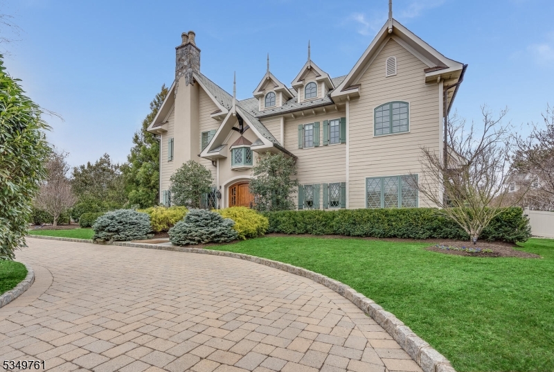 Nestled in Rose Hill Manor, this rare 7,200 sq ft estate blends timeless European design with modern luxury across four impeccably finished levels. A stately exterior of fieldstone, stucco, and copper opens to a dramatic two-story vestibule with vaulted ceilings and a sweeping wrought iron and mahogany staircase. Inside, 10-foot ceilings, red oak floors, arched doorways, & detailed crown moldings echo the grandeur of a European estate. The chef's kitchen features hand-finished cabinetry, professional-grade appliances, and a custom maple island, flowing into the breakfast room and out to a bluestone patio beneath a cedar pergola. A butler's pantry, wine cooler, and walk-in pantry add convenience. Living spaces include a library with Brazilian mahogany and a mezzanine gallery, a formal living room with box beam ceilings, and a family room with a limestone fireplace and barn doors. The primary suite offers vaulted ceilings, a private veranda, sitting room with coffee bar, and a spa bath wrapped in handmade travertine. Additional highlights include a three-stop elevator, media room, wet bar, sauna, fitness room, custom wine cellar, and smart home integration. Outdoors, enjoy bluestone patios, a fire pit, three-season porch with heaters & misting system, and lush, fenced grounds framed by stone pillars. Located just minutes from Madison's vibrant downtown, top-rated schools & direct rail access to Manhattan, this home offers the perfect balance of privacy, prestige, and proximity.