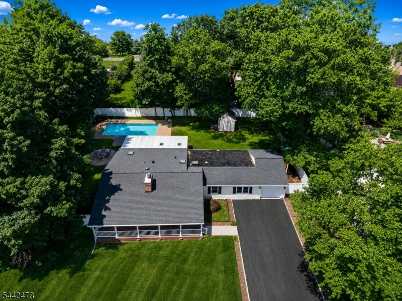 Welcome to this charming and deceptively spacious ranch-style home in the highly sought-after community of Pompton Plains! Offering approximately over 2,100 square feet of comfortable one-floor living, this 3-bedroom, 2-bath residence is much larger than it appears and sits on an oversized lot designed for both relaxation and entertaining. Step onto the inviting front porch and into a warm and welcoming interior featuring hardwood floors, a cozy fireplace in the living room, and an easy-flow floor plan perfect for everyday living. The bright sunroom overlooks the backyard oasis, creating the perfect space to unwind year-round. Outside, enjoy your own private retreat complete with a heated in-ground saltwater pool, basketball court, and plenty of room for gatherings. The expansive driveway accommodates 6-8 vehicles in addition to the attached one-car garage, making parking effortless for guests alike. Additional highlights include a brand-new roof, updated central air conditioning, and the convenience of true single-level living. Ideally located within walking distance to all schools, this home offers the perfect combination of comfort, convenience, and lifestyle in one of Pompton Plains' most desirable neighborhoods. Don't miss this rare opportunity to own a spacious ranch with exceptional outdoor amenities, outstanding curb appeal, and an unbeatable location.