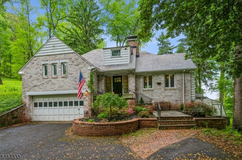 Peaceful privacy & picturesque views in an ideal location! Custom brick Split-Level home with two bedrooms, three full bathrooms & an attached oversized one-car garage is nestled on nearly two private acres. This charming brick gem is perfect for gardeners, naturalists & anyone who enjoys beautiful scenery & proximity to all the amenities this sought-after community has to offer. Highlights include an extra-wide driveway for plenty of parking, warm hardwood floors, a wood-burning fireplace, a walk-up attic, greenhouse room & a huge flagstone patio with an outdoor BBQ/fireplace perfect for entertaining and relaxing. The foyer opens to a large LR with a cozy wood-burning fireplace & a massive picture window offering beautiful views of the rural surroundings. The open flow continues to the dining area & an eat-in kitchen featuring granite counters, stainless steel appliances & a wall of windows looking out on the back yard patio & woods beyond. Upstairs is the primary bedroom with a vaulted ceiling, a second bedroom & a full hallway bathroom. The attic level offers a full bathroom, a bonus room perfect for an office & ample storage space. The lower level includes a large recreation/exercise room, a laundry room, convenient kitchenette, workshop space & a walk-out to the greenhouse. Convenient to routes 202 and 287, this home is close to the NJ Transit direct train to NYC, parks, golf courses, a premier medical center & many shops & restaurants in the bustling downtown area.